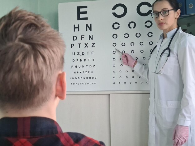 Ophthalmologist checking eyesight of teenage boy