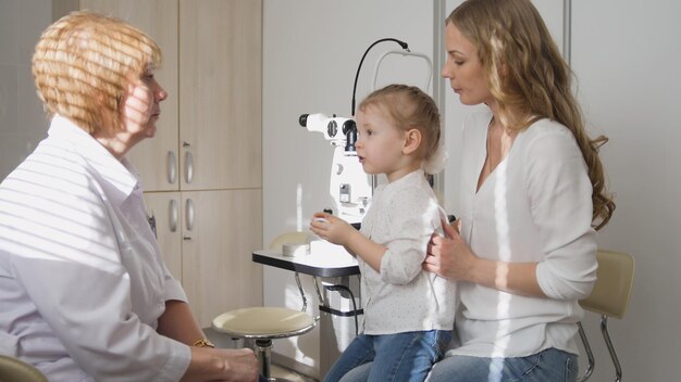 Photo ophthalmologist in clinic explains diagnosis girl's eyesight, horizontal