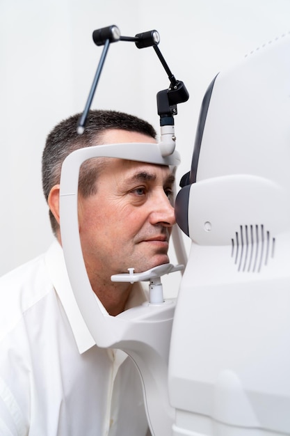 Ophthalmologist doctor exams male patient in optician laboratory. Eye care medical diagnostic. Eyelid treatment. Closeup.