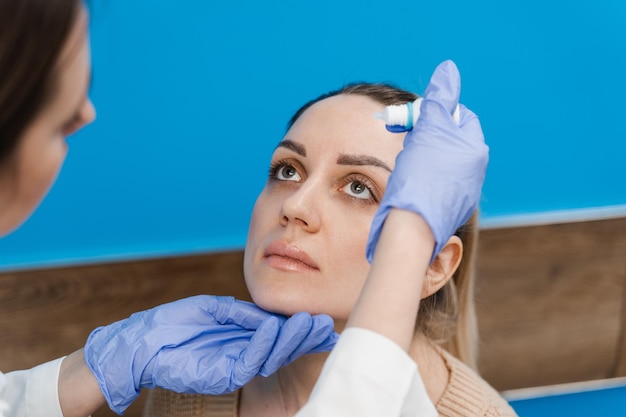 Ophthalmologist drips eye drops into eyes of woman patient for treatment of dry eyes syndrome