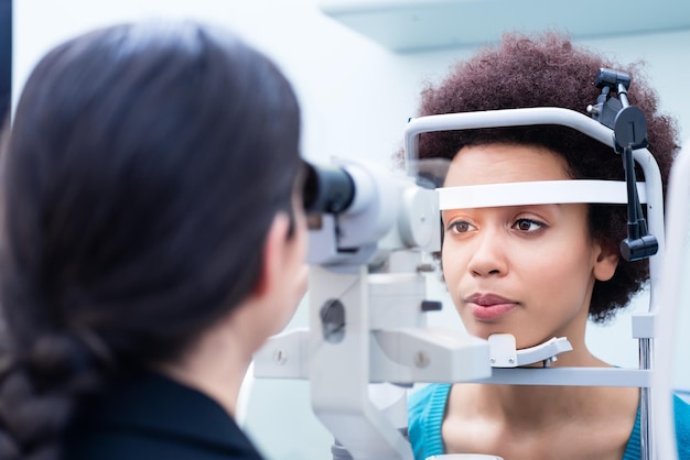 Ophthalmologist examining woman wearing eye test equipment