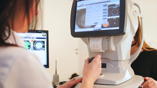 Ophthalmologist in eyes clinic doing diagnostic with vision of patient by modern computer systems