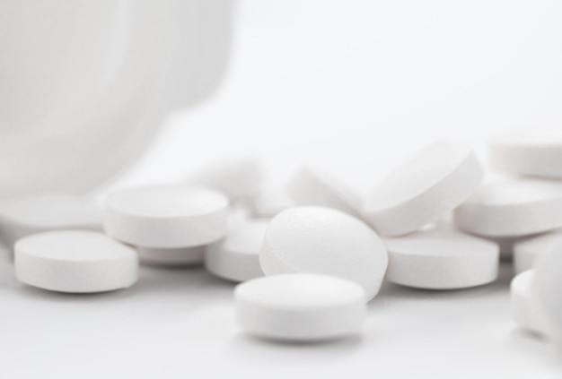 Opioïde pijnstillers verdovende close-up witte pillen met een fles
