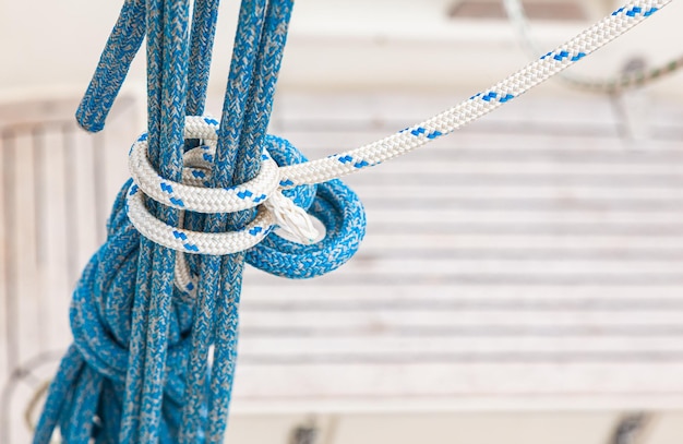 Opknoping nautische touwen vastgebonden in een knoop op een onscherpe achtergrond van het dek van een jacht