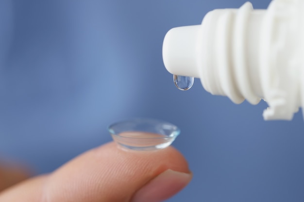 Oplossing wordt gedruppeld op een zacht contactlens-ooglensverzorgingsconcept