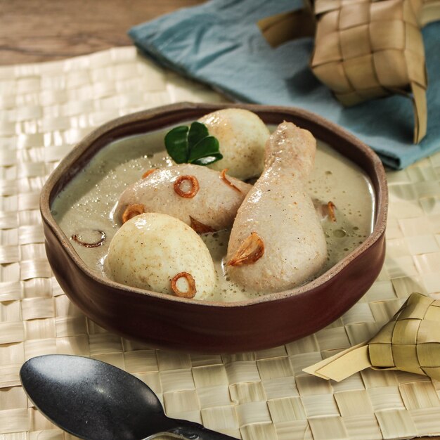 Opor Ayam Telur, Chicken and Boiled Egg Cooked in Coconut Milk from Indonesia, Served with Lontong or Ketupat and Sambal. Popular Dish for Lebaran or Eid al-Fitr