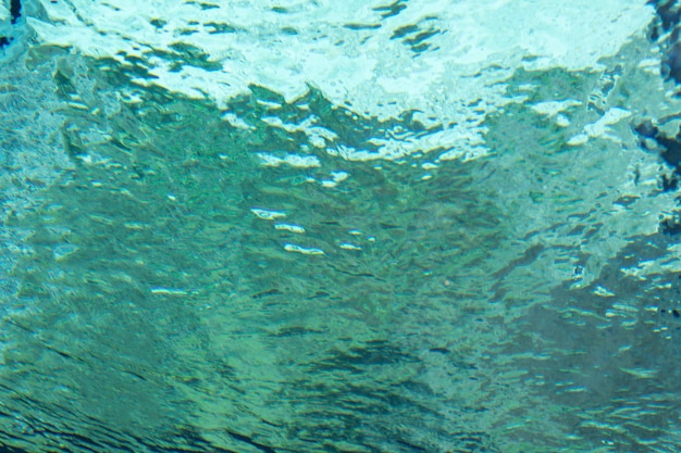 Oppervlak van een zwembad onder water genomen met golven