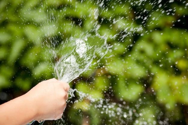 Opspattend water uit de hand van het kind