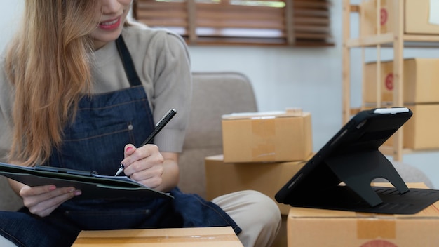 Opstartende kleine ondernemer van freelance Aziatische vrouw met behulp van een laptop met doos Vrolijk succes online marketing verpakkingsdoos en levering MKB idee concept