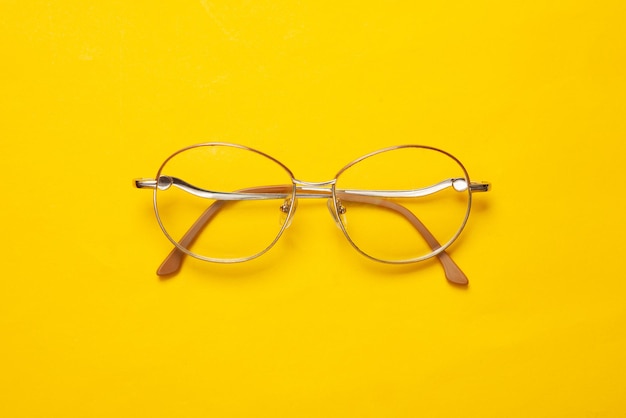Optical eye glasses on yellow background