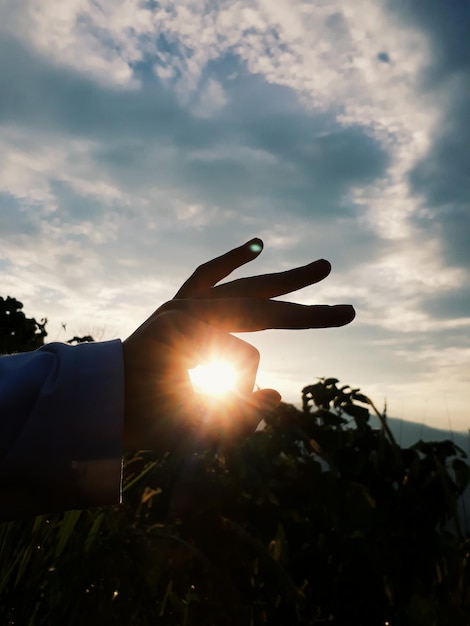 Optical illusion of man holding sun