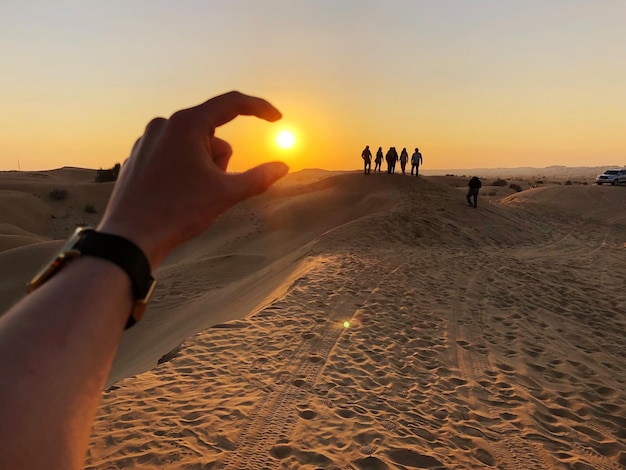Optical illusion of woman hand holding sun at beach