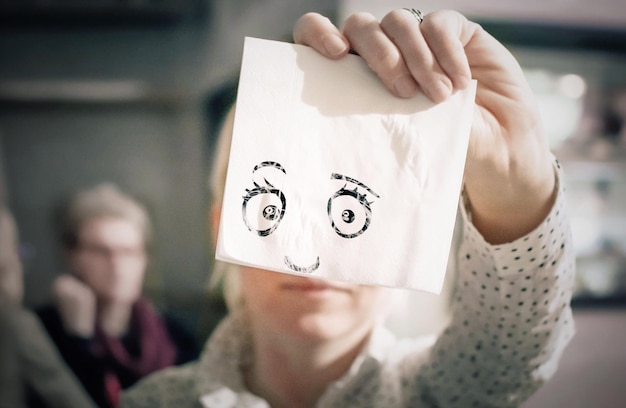Foto illusione ottica di una donna che tiene una faccia antropomorfa su un tessuto