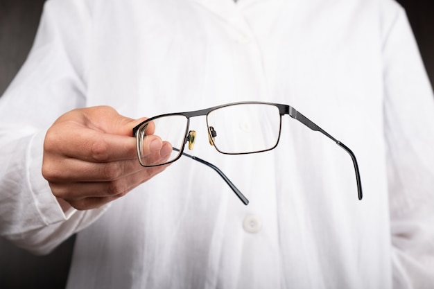 Optician doctor  gives glasses to a patient to improve vision.