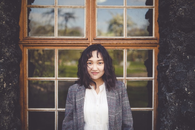 Optimistic asian girl in front of the rustic building