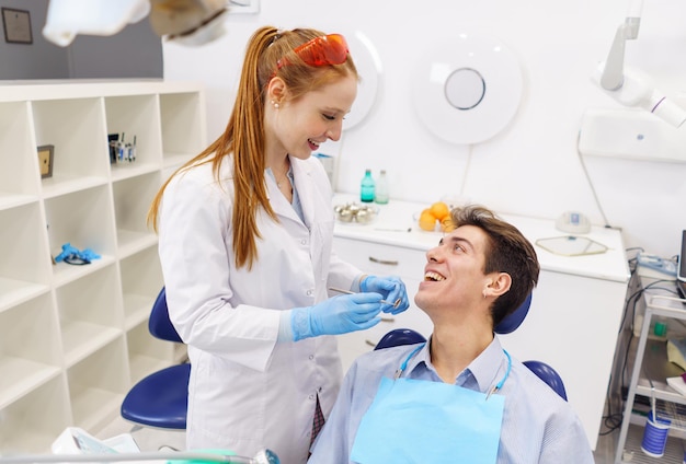 Optimistic dentist and patient looking at each other