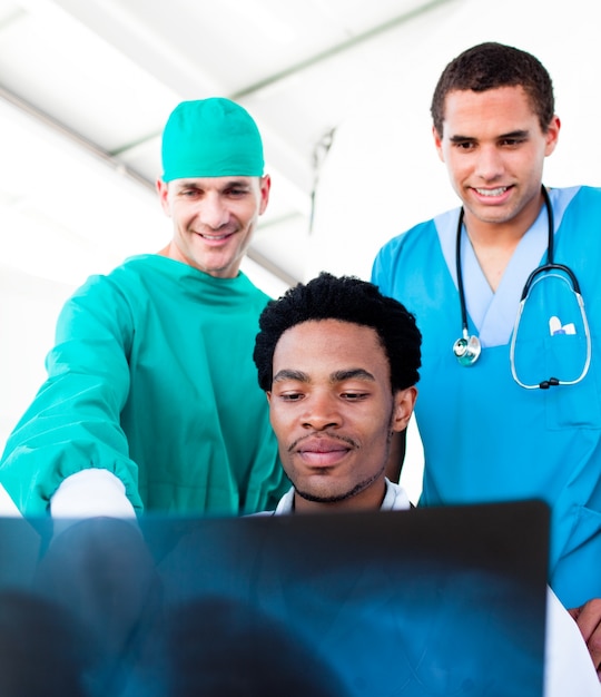 Оптимистичные врачи-мужчины, смотрящие на рентгеновский снимок