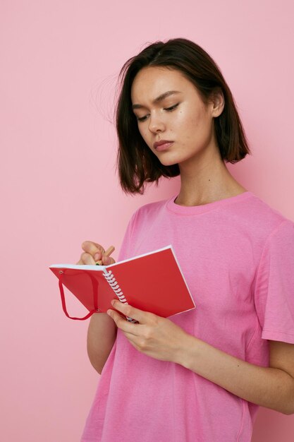 Optimistic young woman emotions posing with notepad learning isolated background