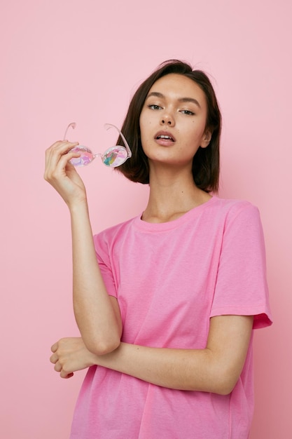 Optimistic young woman glasses in the form of diamonds in a pink tshirt pink background