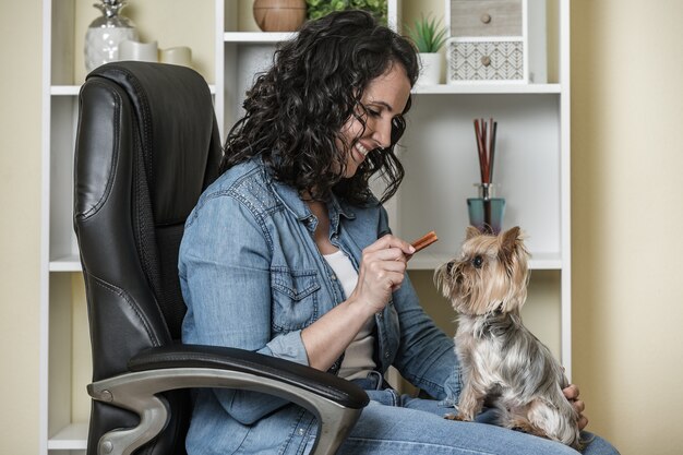 Optimistische dame opleiding hond op stoel