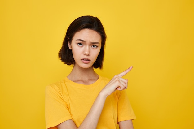 Optimistische jonge vrouw gele t-shirt zomer stijl handgebaar Lifestyle ongewijzigd