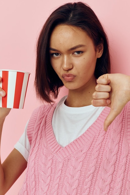 Optimistische jonge vrouw wegwerp drinkglas in een roze tshirt Lifestyle ongewijzigd