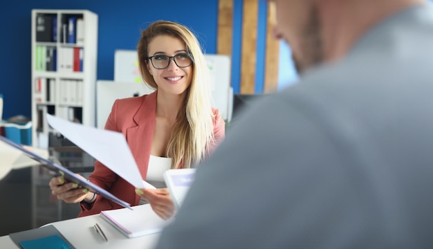 Optimistische vrouw bespreekt handelspapieren met collega-damebaas