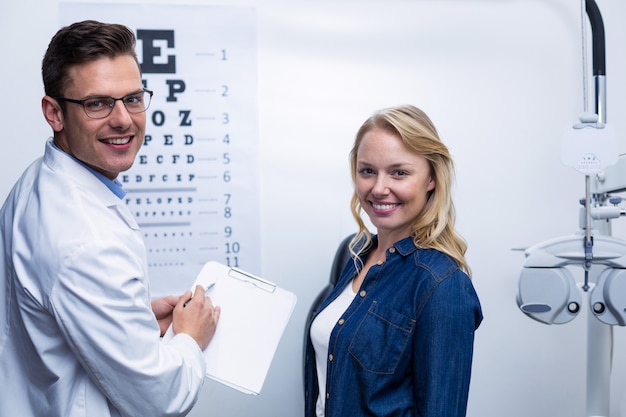 Optometrist discussing eye test report with female patient