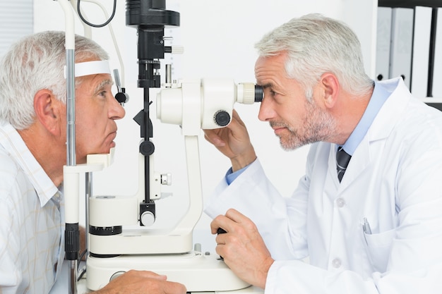 Оптометрист проводит зрение для старшего пациента