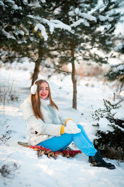 Opvatting van de wintervakantie Vrolijk meisje in warme kleren spelen met sneeuw