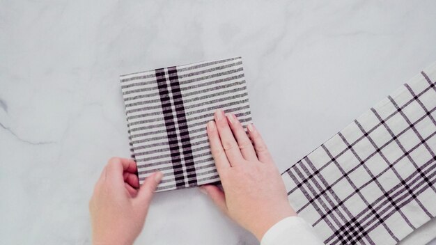 Opvouwbare papieren handdoeken met zwart en wit patroon op marmeren oppervlak.