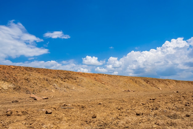 Opwarming van de aarde dor land met blauwe lucht en wolken