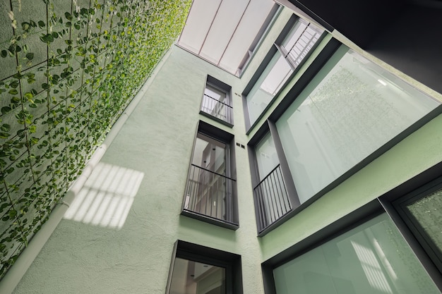 Opzoekweergave van modern woongebouw met verticaal tuinieren in barcelona zwart frame ramen...