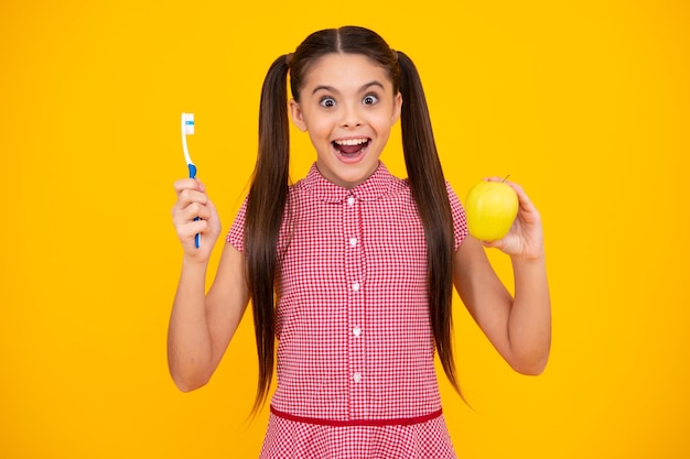 Гигиена полости рта стоматология Девочка-подросток чистит зубы Подросток держит зубную щетку в руке чистит зубы утренняя гигиена полости рта уход за зубами Яблочные витамины для здоровых зубов