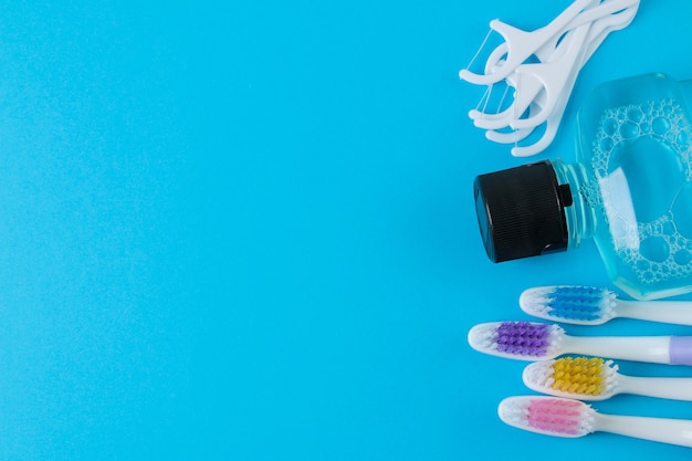 Oral hygiene. Multi-colored toothbrush and mouthwash on a bright blue. top view