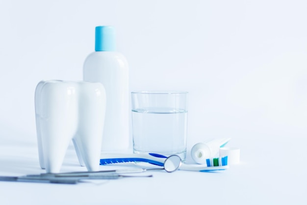 Oral hygiene products and model of tooth on white background