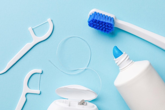 Oral hygiene products Toothbrush with toothpaste and dental floss on a blue background