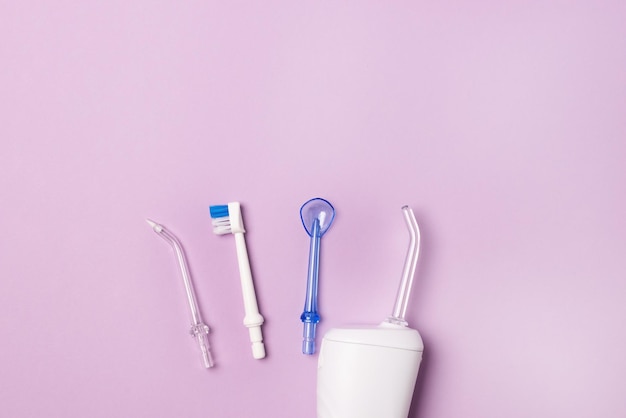 Foto orale hygiëneset orale tanden irrigator tandvlek tongschraper roze achtergrond