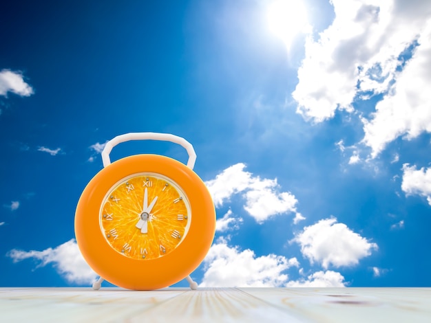 Photo orange alarm clock on blue sky background