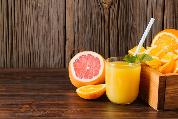 写真 木製の背景にオレンジとグレープフルーツのジュース