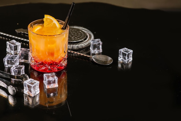 Foto cocktail di aperol arancione con ghiaccio su sfondo scuro