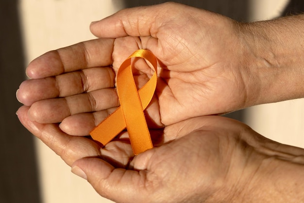 Orange august Multiple Sclerosis Awareness Campaign Hand holding orange ribbon