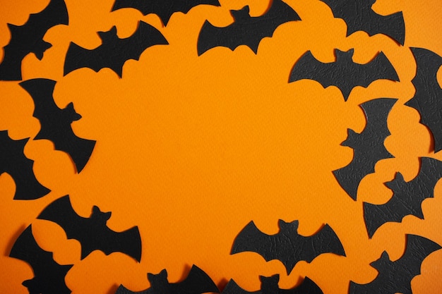 Foto sfondo arancione con pipistrelli neri con spazio per il testo