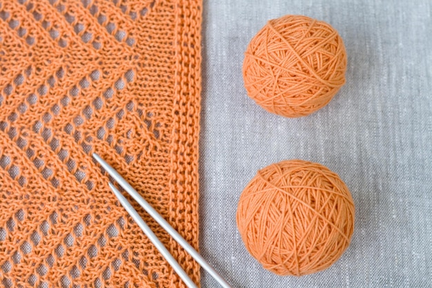 Orange balls knitted pattern and knitting needles