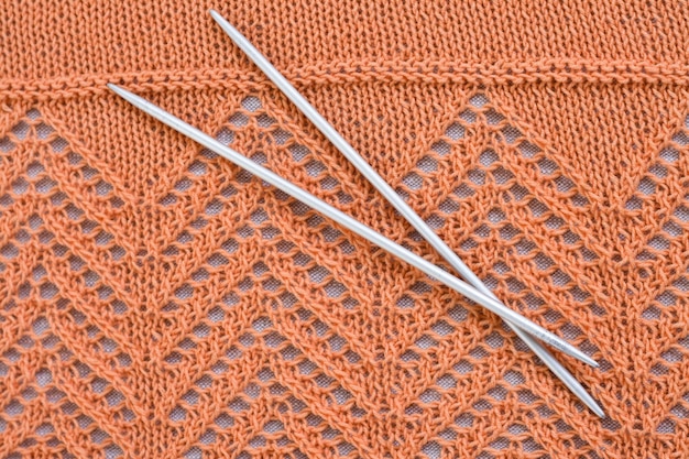 Orange balls knitted pattern and knitting needles