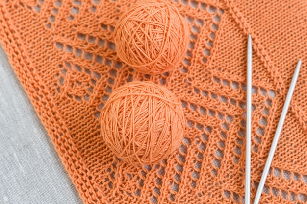 Orange balls knitted pattern and knitting needles