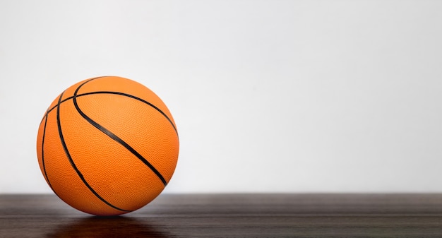 Оранжевый баскетбольный мяч в спортивном зале на размытом фоне. Скопировать пространство