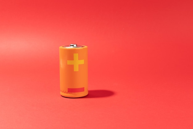 Orange battery on red background