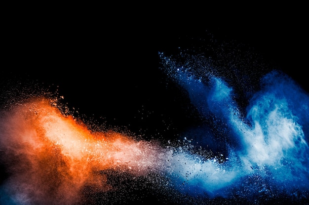 Orange blue color powder explosion on black background.