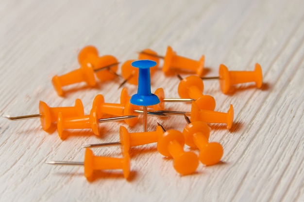 Orange and Blue Pushpins Heap on White Wood